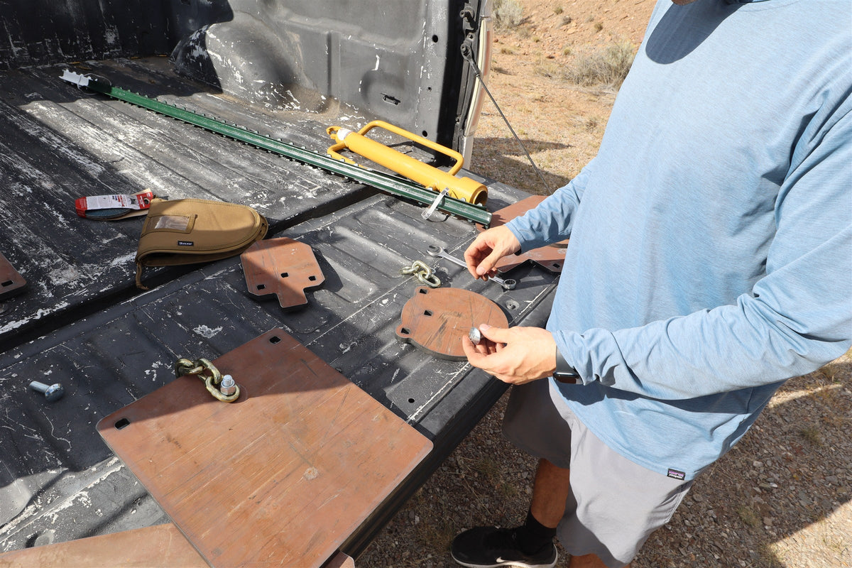 T-post driver, hanger hardware and Surface Rust steel targets laid out on a truck tailgate