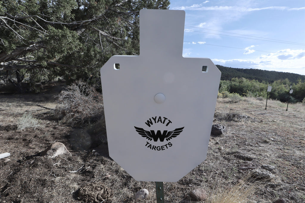 66-percent IPSC silhouette, 1/2-inch AR500 steel, white paint, three 9/16-inch square mounting holes, mounted on a T-post