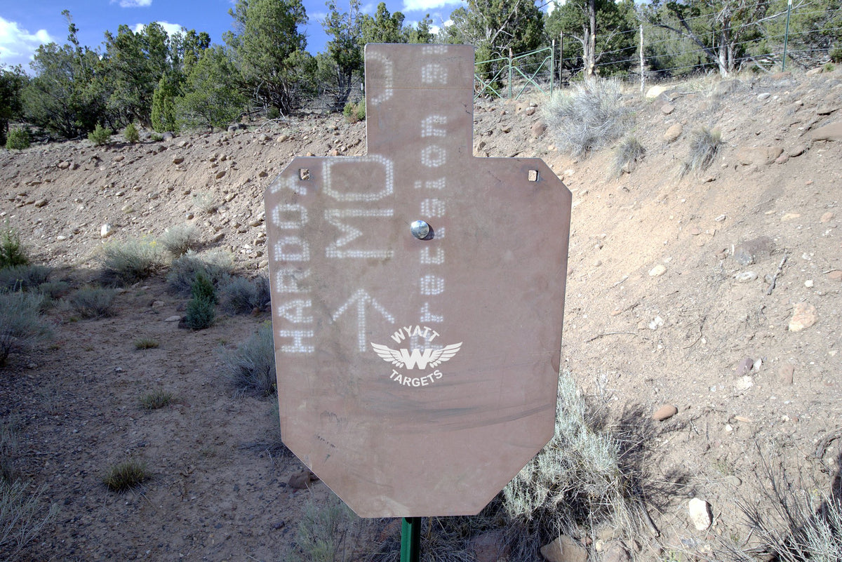 100-percent IPSC silhouette, 1/2-inch AR500 steel, surface rust, three 9/16-inch square mounting holes, mounted on a T-post